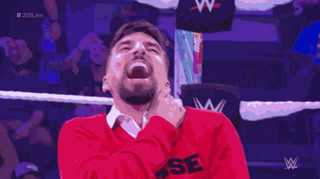 a man laying on the ground in a wrestling ring with a referee