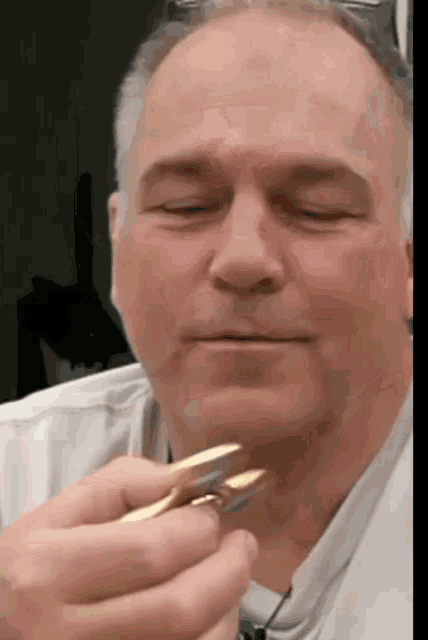 a man with his eyes closed is holding a gold object