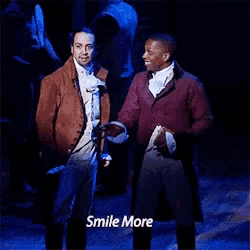 two men are standing next to each other on a stage with the words `` smile more '' written on the bottom .