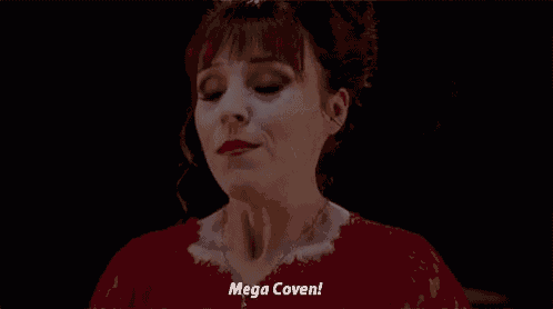 a woman in a red dress is making a funny face and saying mega coven .