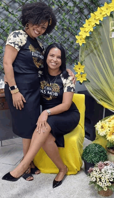 two women wearing black shirts that say das mdb