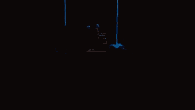 a man in a blue helmet is standing on a stage in a dark room