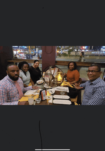 a group of people sitting at a table with a menu on it that says ' dinner ' on it