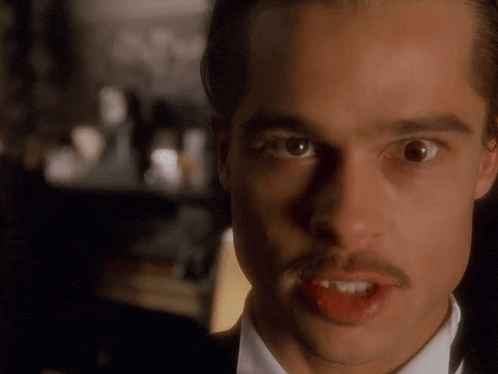 a man with a mustache is making a funny face with his tongue sticking out .