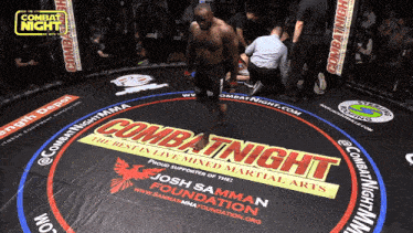 a man in a boxing ring with combat night mma written on it