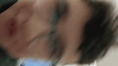 a blurry picture of a person 's face with a blue background