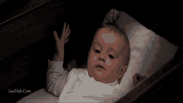 a baby is laying in a crib with the website isaidub.com visible in the corner