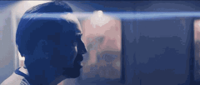 a close up of a man 's face with a blue light shining on it