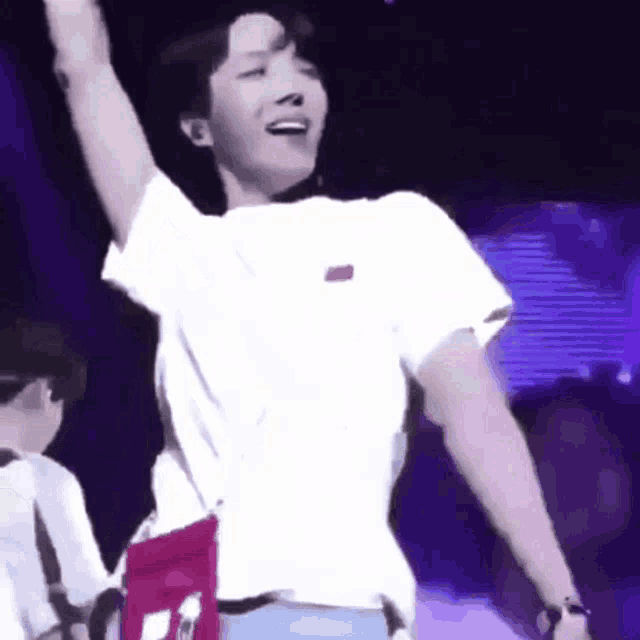 a man is standing on a stage with his arms in the air and smiling .