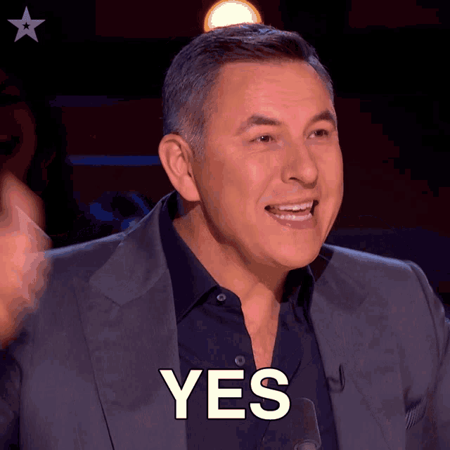 a man in a suit says yes in front of a star