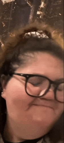 a woman wearing glasses is making a face