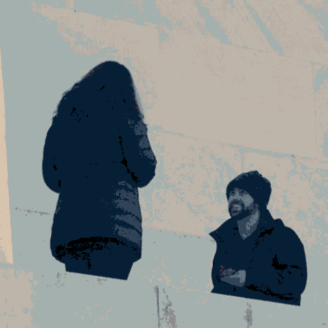 a woman in a black jacket stands next to a man in a black jacket