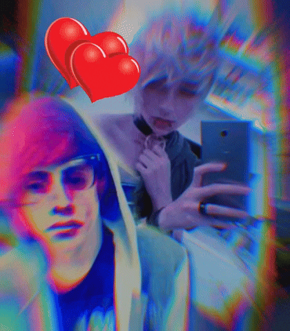 a man taking a selfie next to a woman with two red hearts above her head