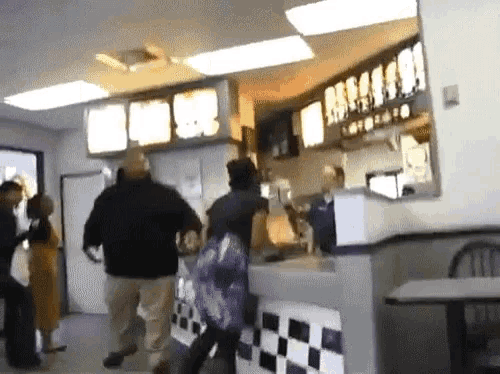 people are standing in a restaurant with a sign that says ' a ' on it
