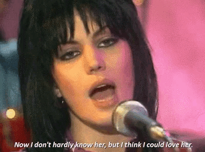 a close up of a woman singing into a microphone