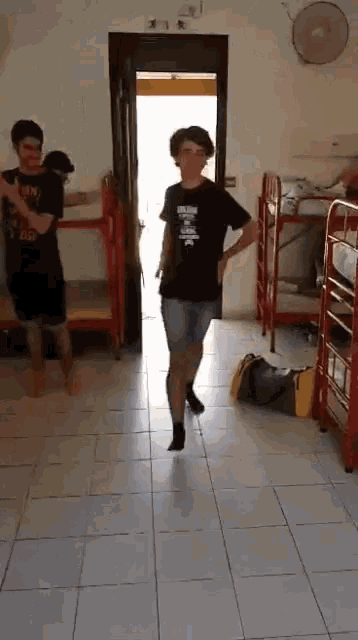 a boy wearing a black shirt that says ' i love you ' on it is dancing in a dorm room