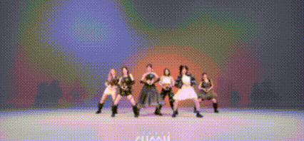 a group of women are dancing on a stage in a blurry photo .