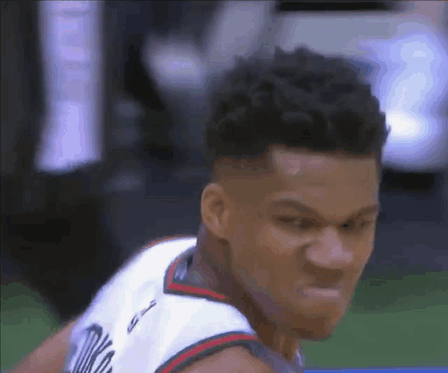 a close up of a basketball player making a funny face while playing basketball .