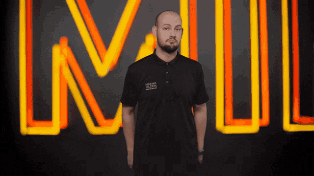 a man stands in front of a neon sign that says ln on it