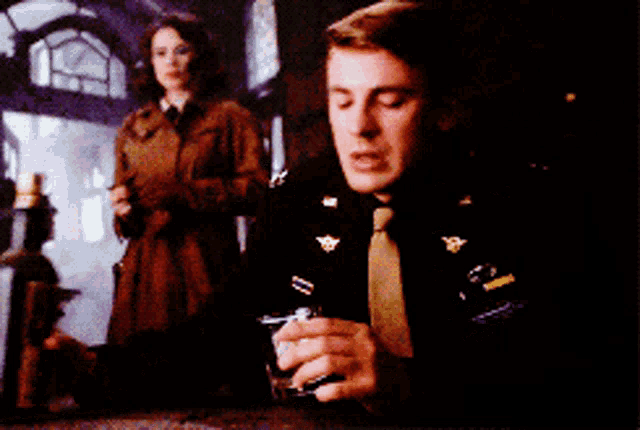 a man in a military uniform is holding a bottle of wine