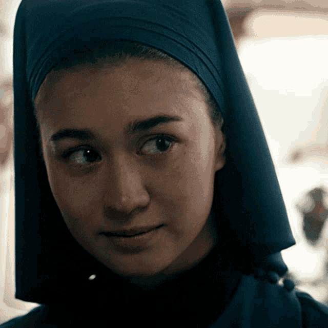 a woman wearing a turban looks at the camera