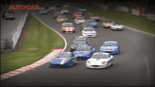 a bunch of cars are racing on a track and the word autocar is on the bottom right
