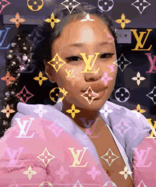 a girl wearing a pink louis vuitton jacket looks at the camera