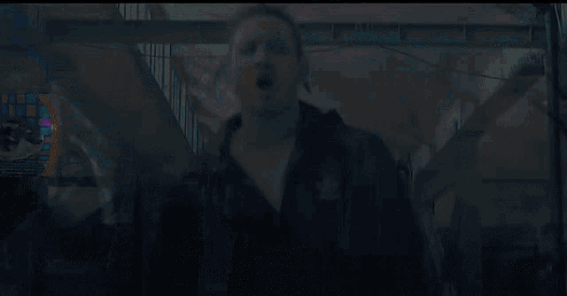 a man wearing a black adidas jacket stands in front of a large eye