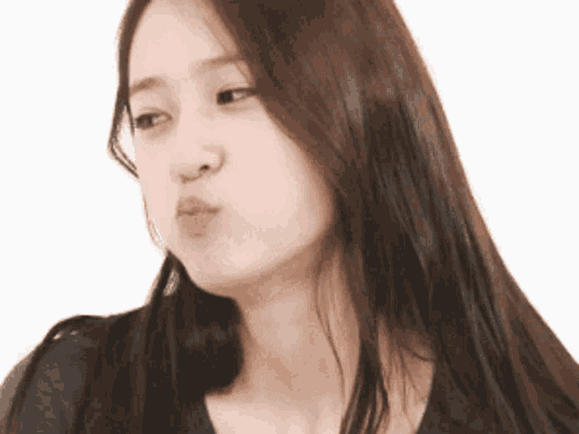 a woman with long hair is blowing a kiss at the camera