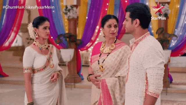 a man and two women are standing next to each other in a room with a starplus logo in the corner