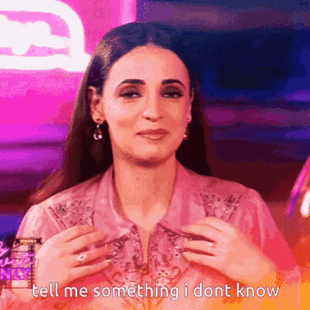 a woman in a pink shirt says tell me something i don t know