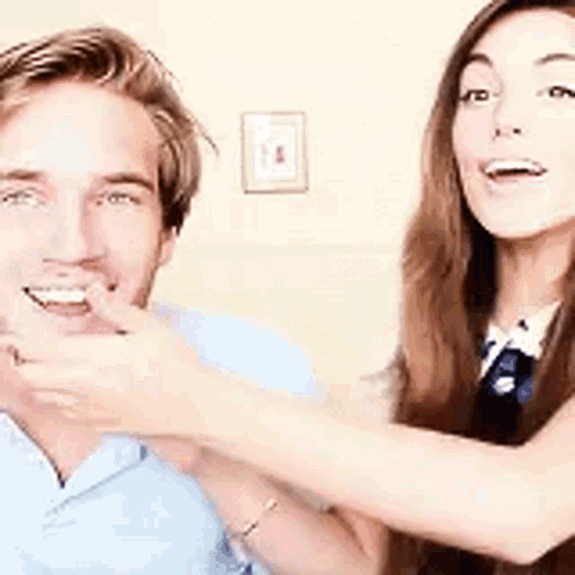 a man and a woman are standing next to each other and smiling for the camera .