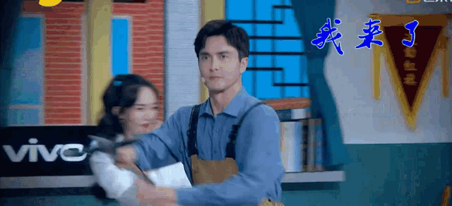 a man is holding a woman in his arms in front of a vivo sign