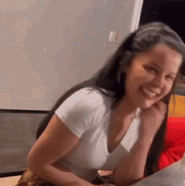 a woman is smiling while sitting at a table .
