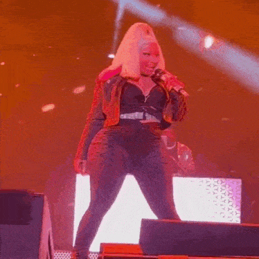 a woman is singing into a microphone on a stage .