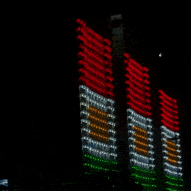 a building with red white and green lights on the side