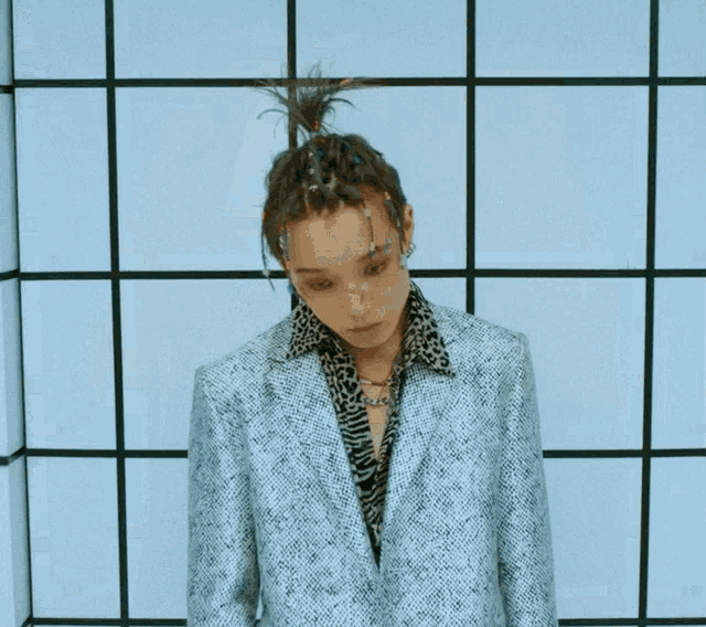 a man wearing a leopard print shirt and a silver jacket