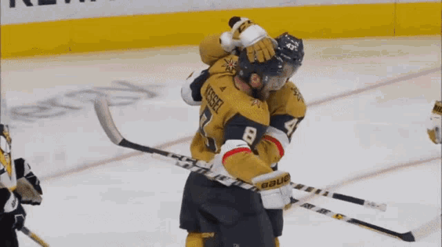 two hockey players are hugging each other and one has the number 8 on his jersey