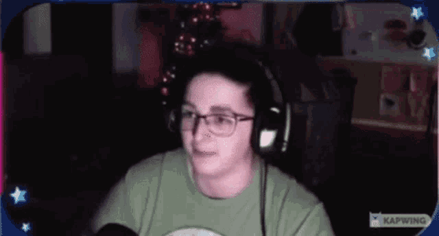 a man wearing headphones is sitting in front of a microphone .