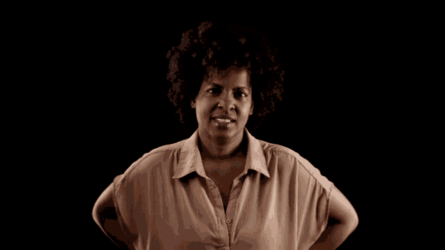 a woman with her hands on her hips is smiling for the camera