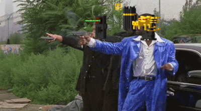 a man in a blue suit points a gun at another man in a black suit