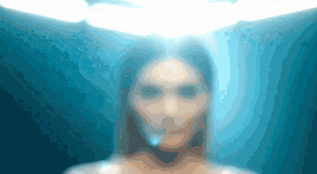 a blurry picture of a woman 's face with a light shining on it