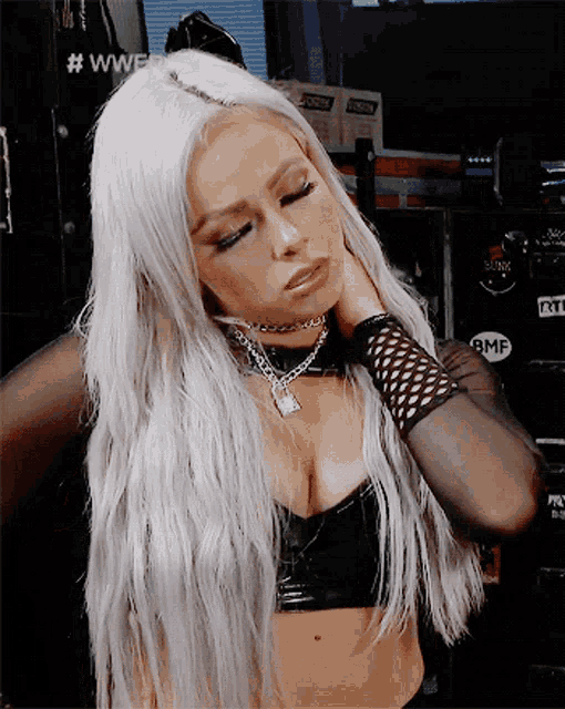 a woman with long white hair is wearing a black crop top