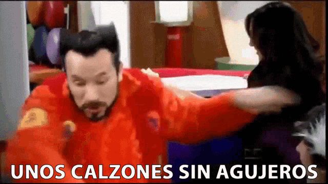 a man in a red shirt is standing next to a woman with the words unos calzones sin agujeros written on the bottom