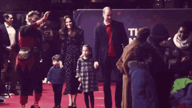 a group of people on a red carpet with a sign that says ti on it