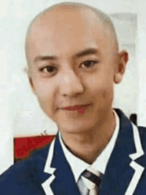 a bald man wearing a suit and tie is smiling .