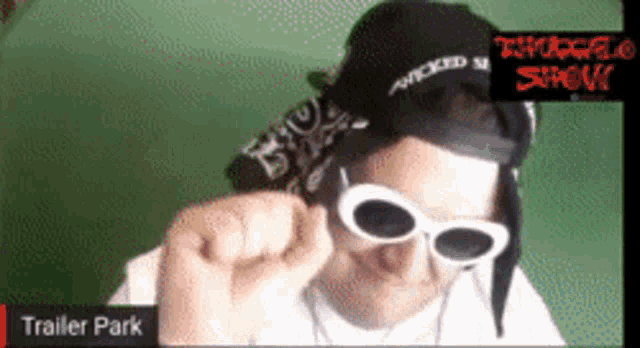 a man wearing sunglasses and a bandana is in a trailer park
