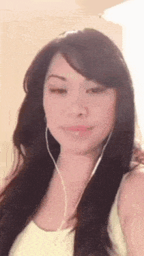 a woman wearing headphones looks at the camera