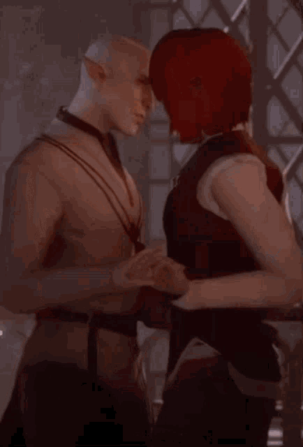 a man and woman kissing in front of a window