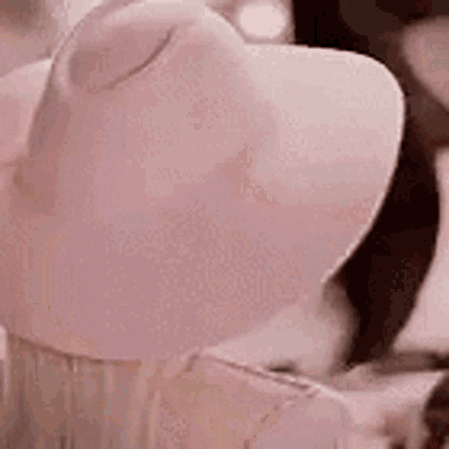a close up of a person wearing a pink hat .